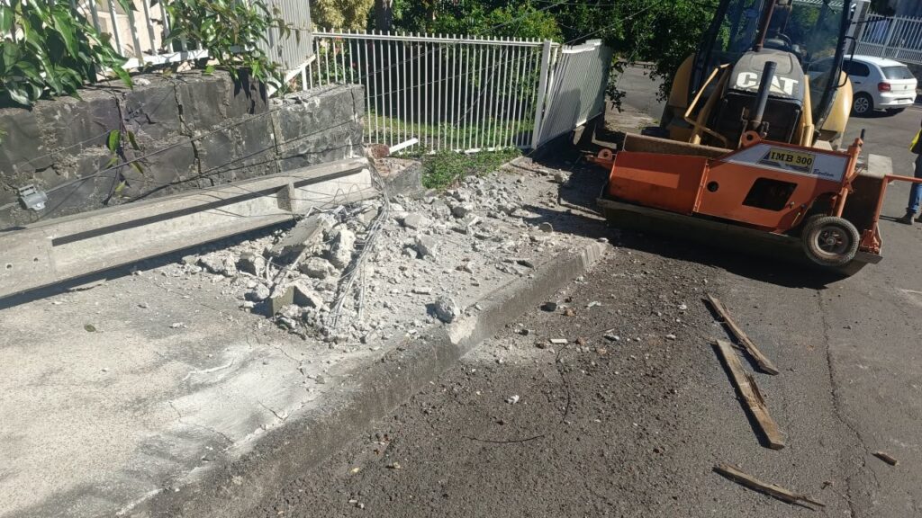 Retroescavadeira cai de caminhão e atinge muro de residência em Concórdia